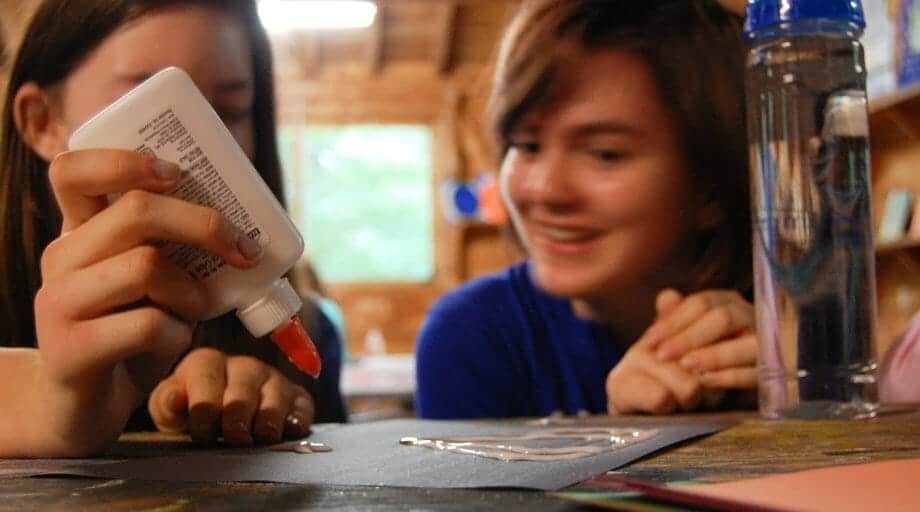 Two campers glueing a craft project
