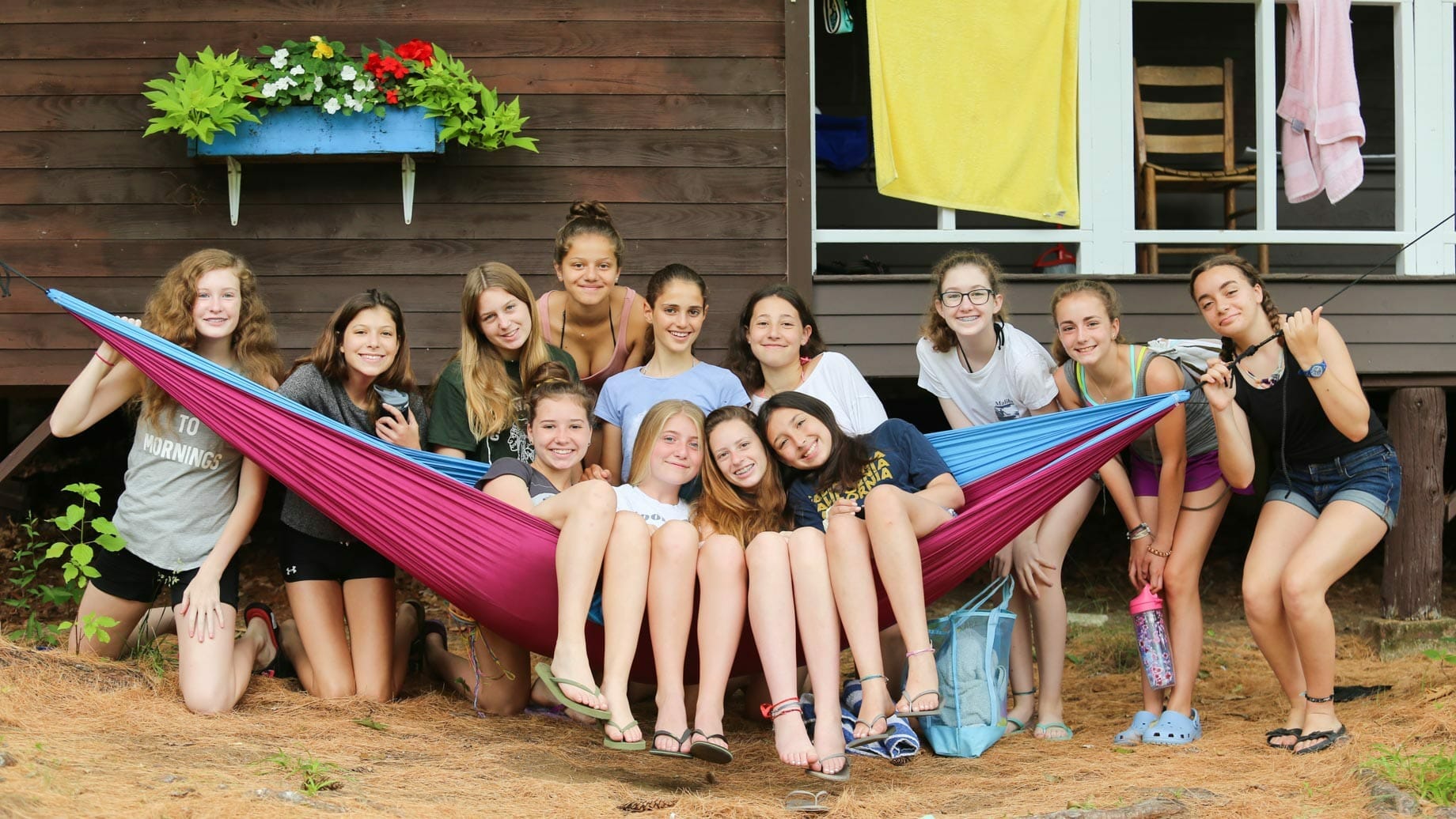 Girls posing on hammock by cabin