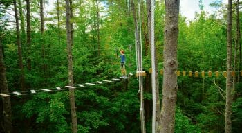 Camper walking across bridge on the high ropes course