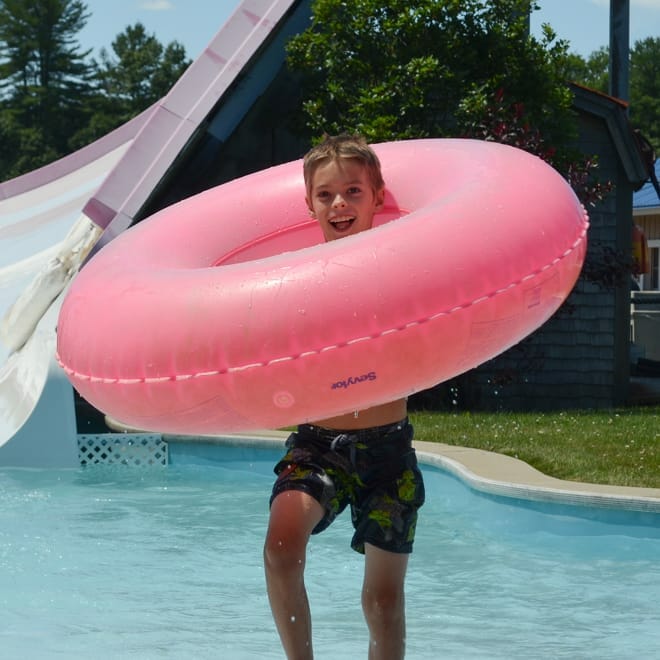 Boy on an off camp trip to a waterpark with a tube