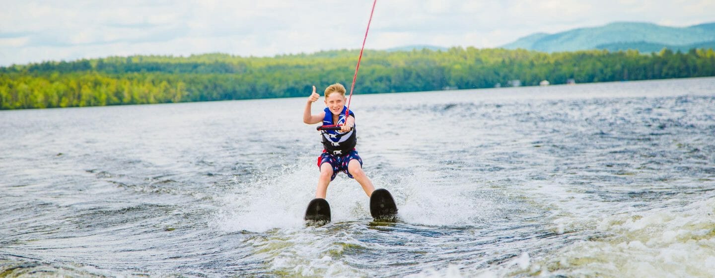 Boy waterskiing and giving thumbs up