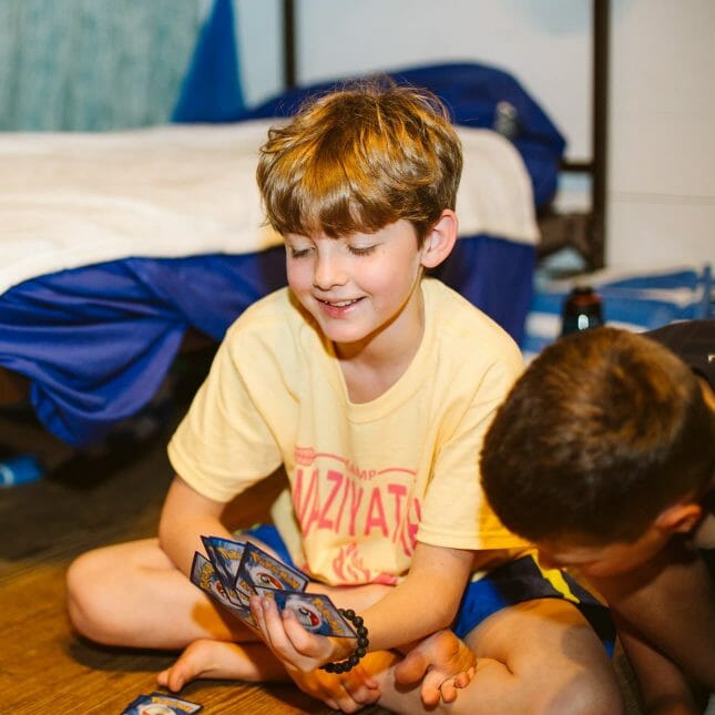 Boys playing cards in their Wazi cabin