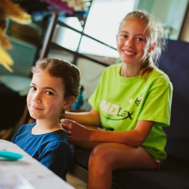 Girl's braiding each other's hair in their Wazi cabin