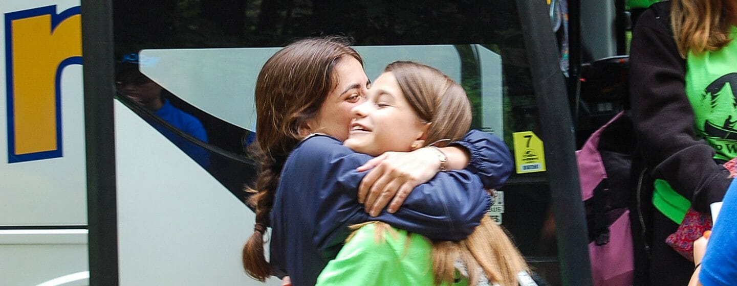 Two girls hugging on arrival day to camp