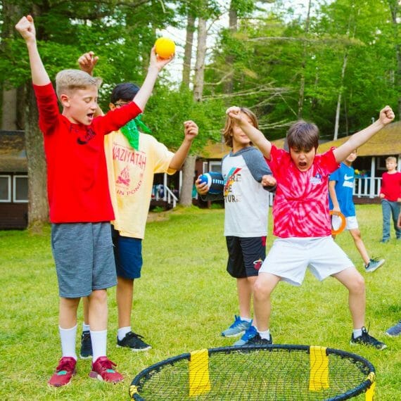 Boys playing spike ball and cheering