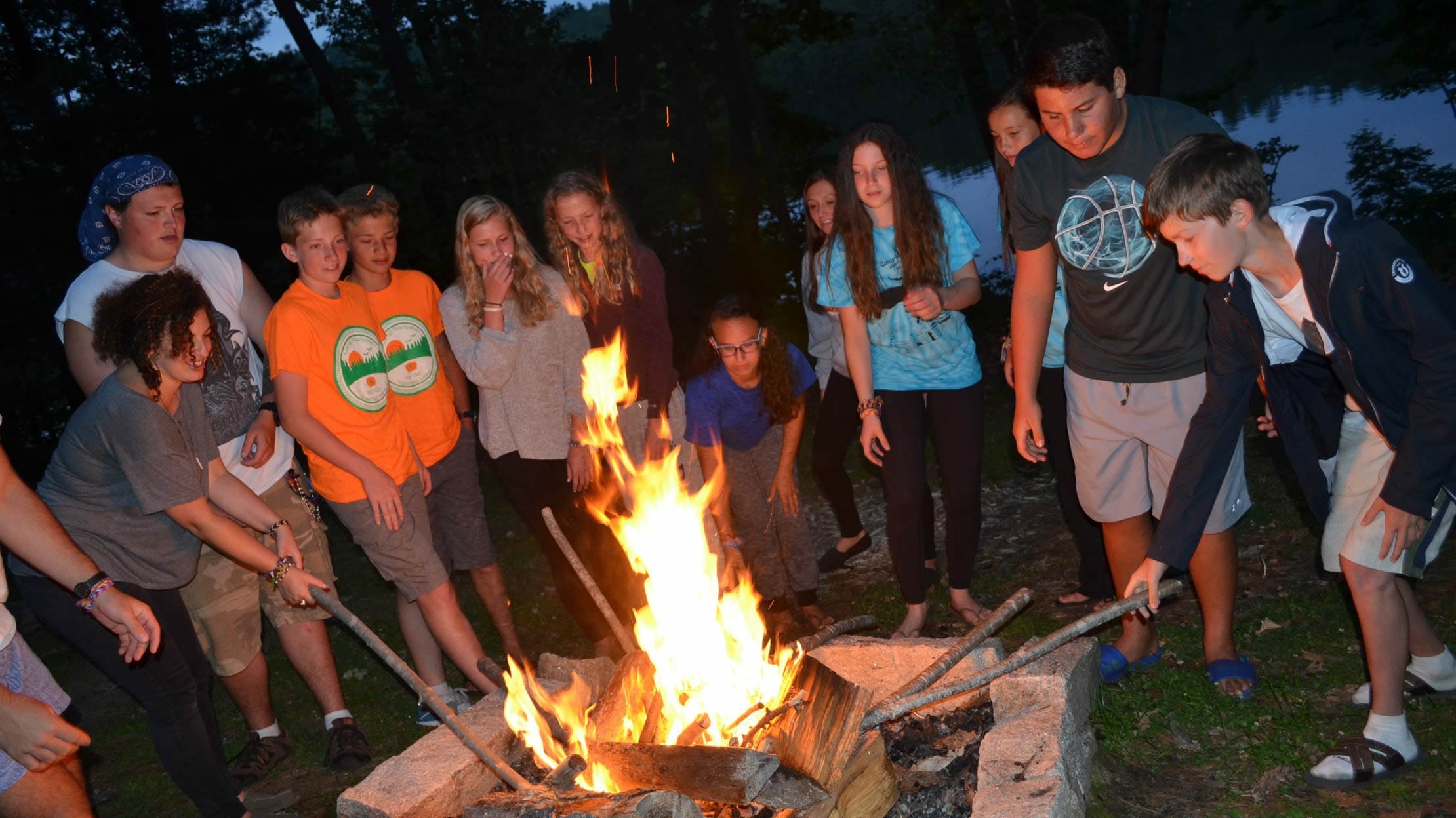 Campers at campfire roasting marshmallows