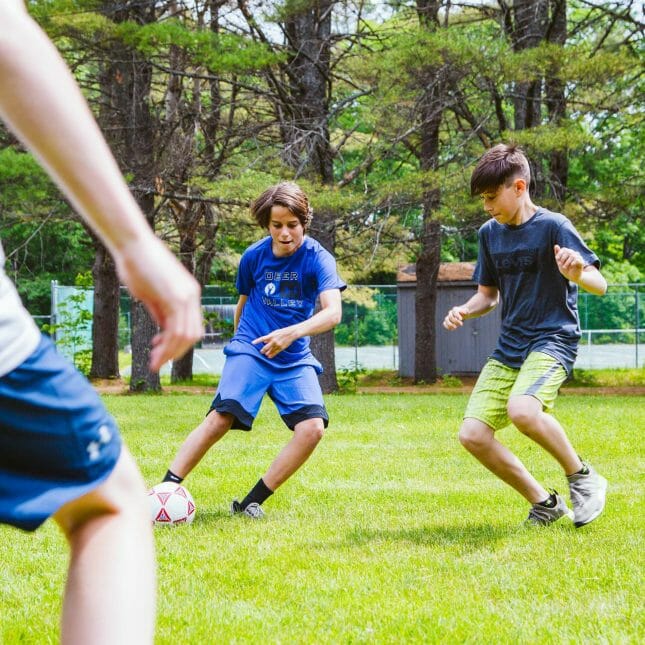 Two boys playing soccer on the field