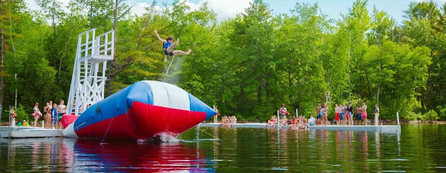 Boy being launched from The Blob at camp